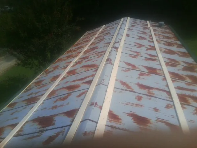 Rusted metal roof panels with new wood purlins before replacement — Storm Damage Roof Repair in Mill Spring by Roofing Brothers